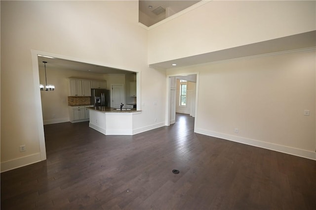 227 Westover St, Auburn, AL 36832 - unfurnished living room with dark wood-type flooring and a chandelier