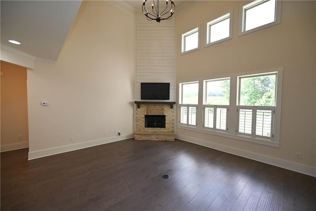 227 Westover St, Auburn, AL 36832 - unfurnished living room with crown molding, a towering ceiling, a fireplace, plenty of natural light, and a chandelier