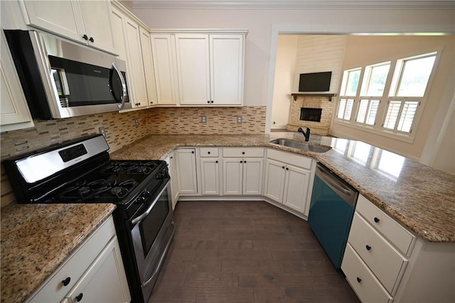 227 Westover St, Auburn, AL 36832 - kitchen featuring stainless steel appliances, a peninsula, tasteful backsplash, white cabinets, and ornamental molding