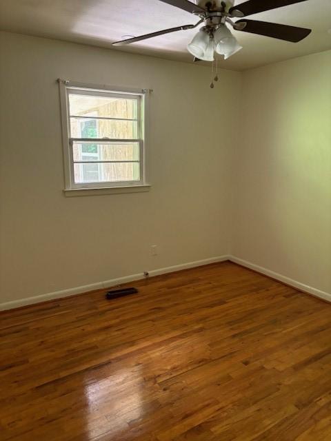 unfurnished room with dark hardwood / wood-style flooring