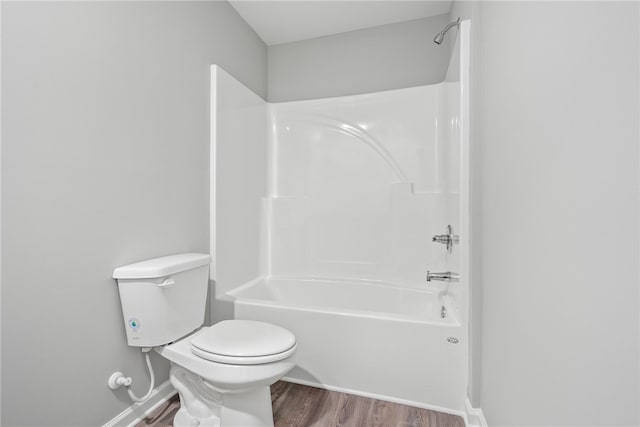 bathroom featuring shower / bathing tub combination, toilet, and wood-type flooring