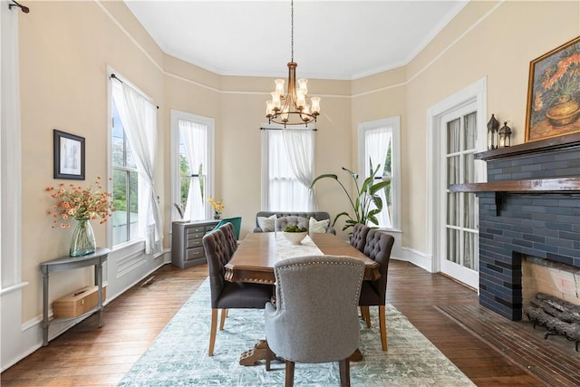 1008 3rd Ave, Opelika, AL 36801 - dining space with a chandelier, ornamental molding, wood-type flooring, and a brick fireplace