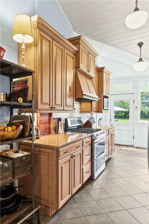 1008 3rd Ave, Opelika, AL 36801 - kitchen with double oven range, light tile patterned floors, pendant lighting, brown cabinetry, and light stone countertops
