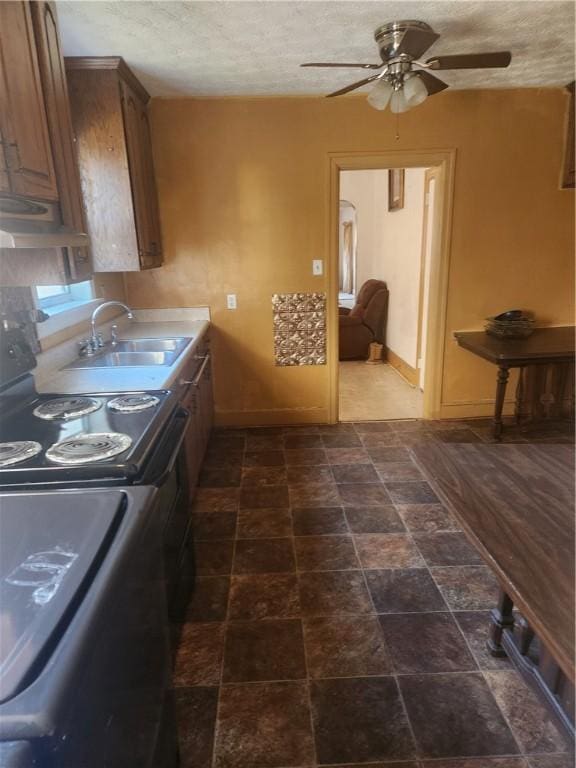 kitchen with a textured ceiling, ceiling fan, range with electric cooktop, and sink