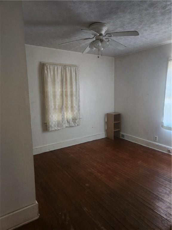 spare room featuring ceiling fan, a textured ceiling, and dark wood-type flooring