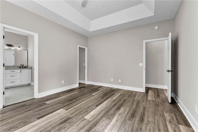 1661 S Camden Ct, Auburn, AL 36830 - unfurnished bedroom with a raised ceiling, wood finished floors, and ensuite bathroom