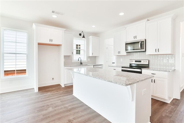 112 Hunters Way, Opelika, AL 36801 - kitchen with stainless steel appliances, a kitchen island, tasteful backsplash, light wood-style flooring, and recessed lighting