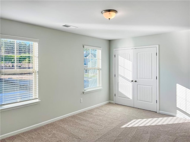 carpeted empty room featuring plenty of natural light