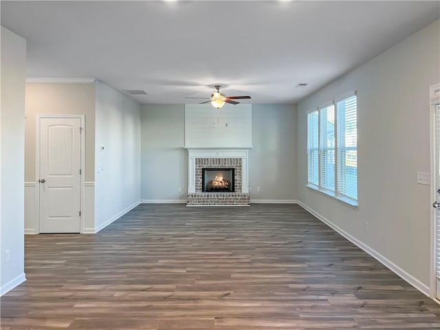 unfurnished living room featuring dark hardwood / wood-style floors, a brick fireplace, and ceiling fan