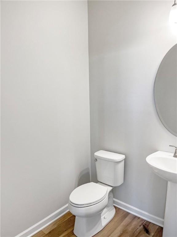 bathroom featuring hardwood / wood-style flooring and toilet