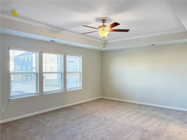 spare room featuring ceiling fan, ornamental molding, light carpet, and a tray ceiling