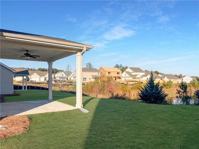 view of yard with ceiling fan and a patio