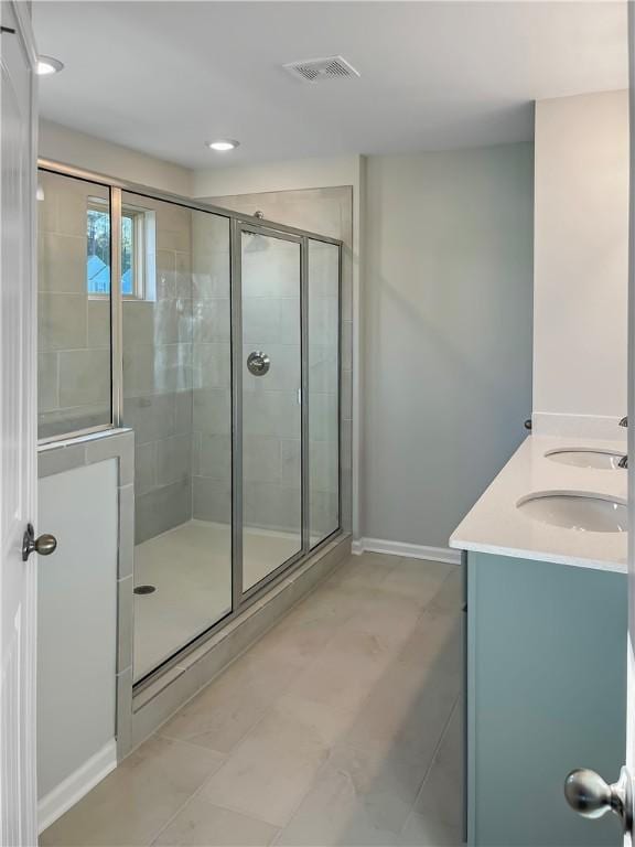 bathroom featuring tile patterned flooring, vanity, and an enclosed shower