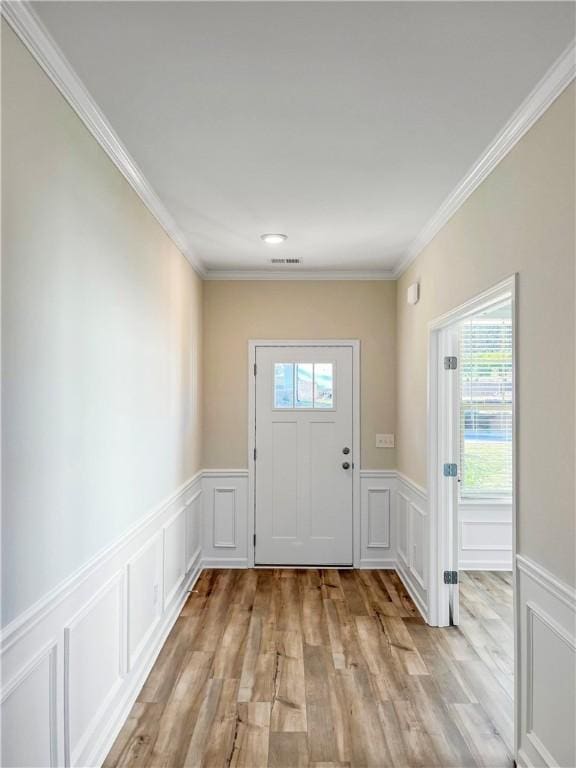 doorway featuring light wood-type flooring and ornamental molding