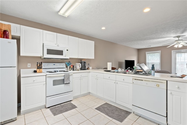 1477 N Donahue Dr Unit 1708, Auburn, AL 36830 - kitchen featuring white appliances, a textured ceiling, light countertops, white cabinetry, and recessed lighting