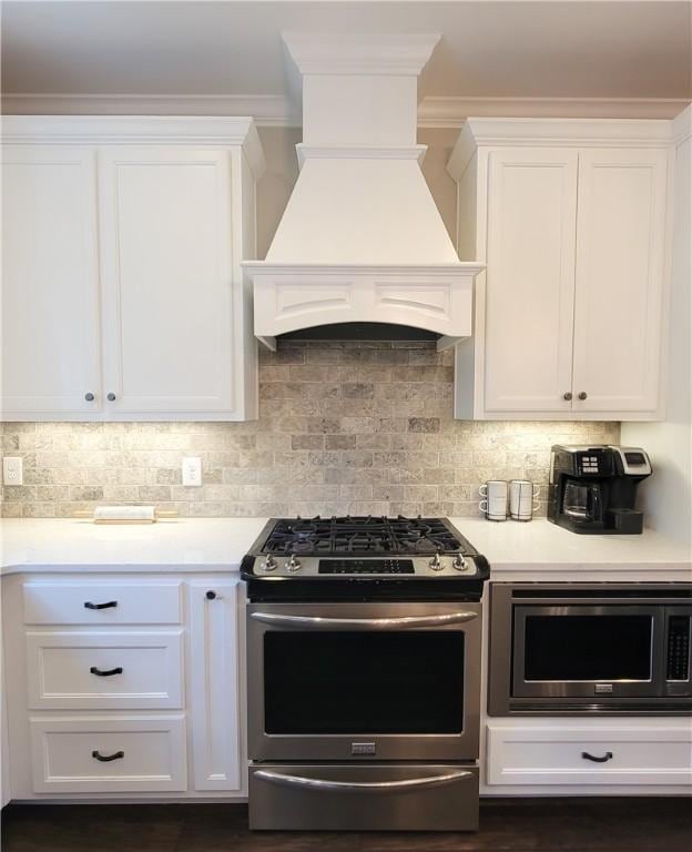 3615 Eagle Nest, Opelika, AL 36801 - kitchen with custom range hood, tasteful backsplash, white cabinetry, appliances with stainless steel finishes, and light countertops