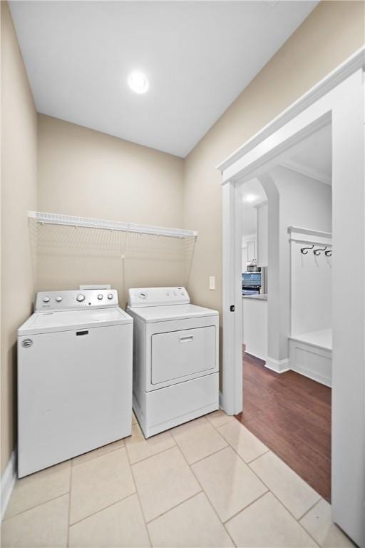 laundry room featuring washer and clothes dryer and light tile patterned flooring