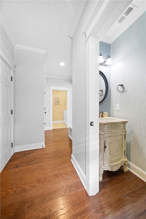 corridor with hardwood / wood-style flooring and ornamental molding