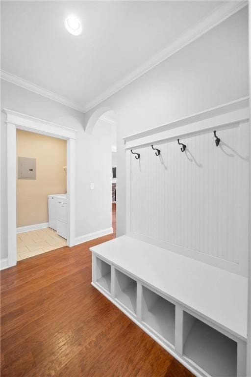 mudroom featuring hardwood / wood-style floors, ornamental molding, and washing machine and clothes dryer