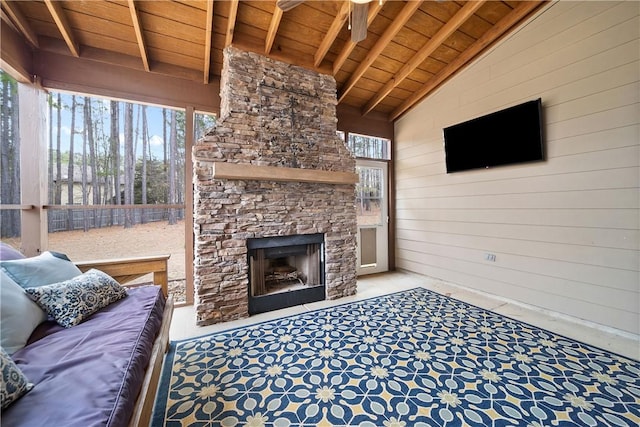 living room with wood ceiling, wood walls, lofted ceiling with beams, and an outdoor stone fireplace