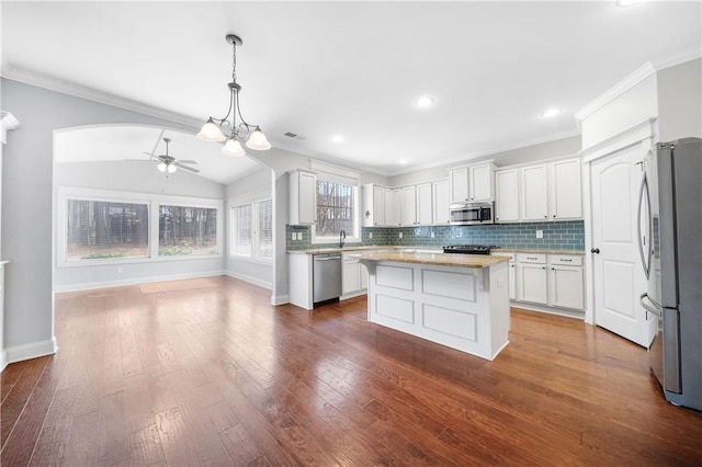 kitchen with a kitchen island, appliances with stainless steel finishes, dark hardwood / wood-style floors, white cabinets, and hanging light fixtures