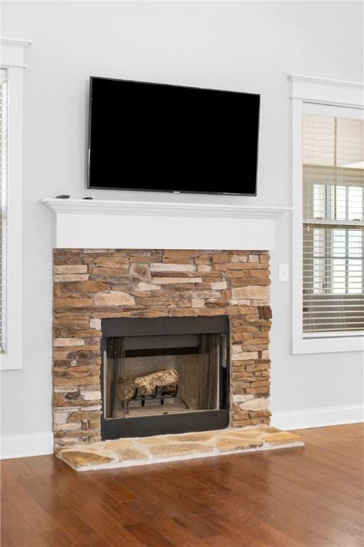 interior details featuring hardwood / wood-style flooring and a stone fireplace