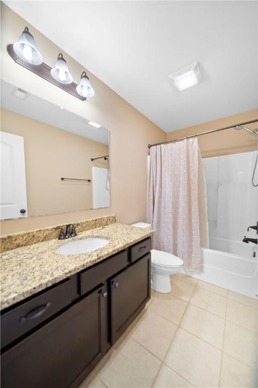 full bathroom with tile patterned flooring, shower / bath combo, vanity, and toilet