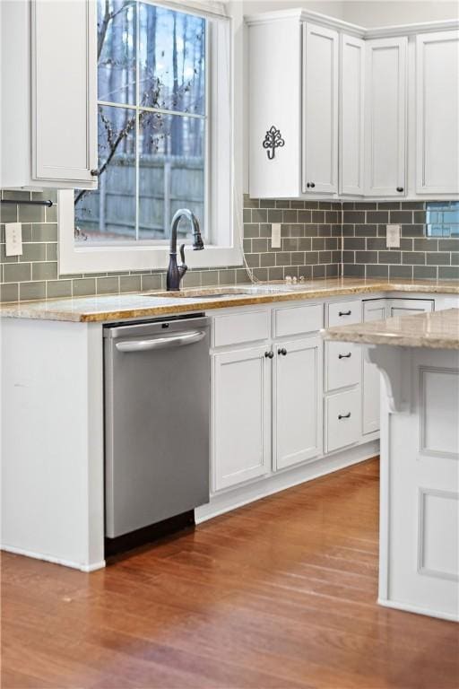 kitchen featuring dishwasher, white cabinets, light hardwood / wood-style floors, and decorative backsplash