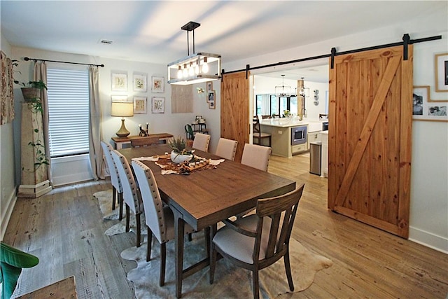 3897 Moores Mill Rd, Auburn, AL 36830 - dining room with a barn door and light wood-type flooring