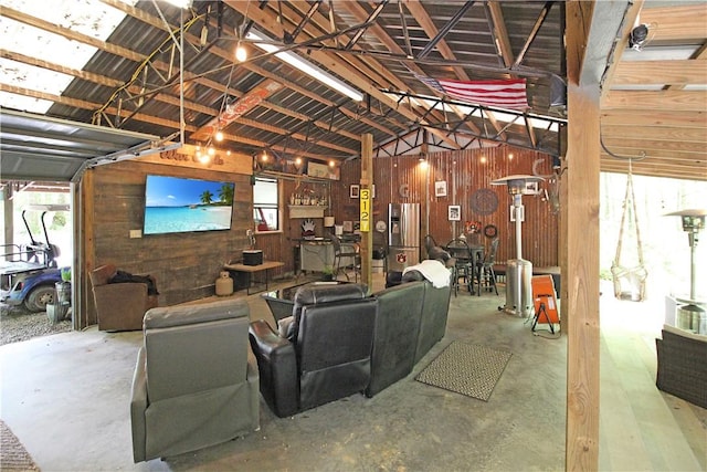 3897 Moores Mill Rd, Auburn, AL 36830 - living room with wood walls, vaulted ceiling, and concrete flooring