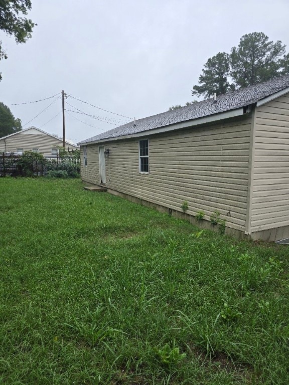 view of side of home with a yard