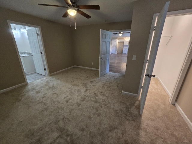 unfurnished bedroom with connected bathroom, light colored carpet, and ceiling fan