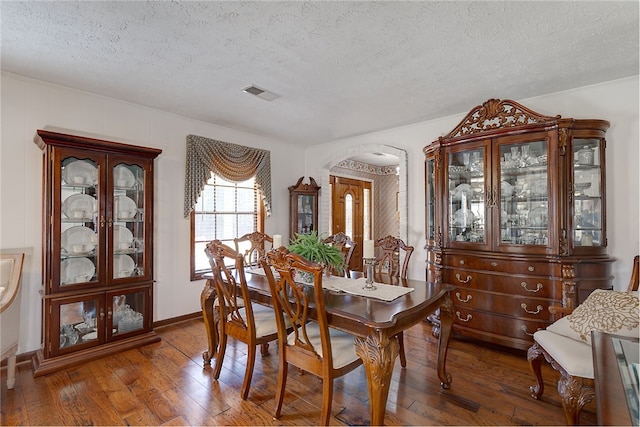 2071 County Road 63, Tuskegee, AL 36083 - dining area featuring a textured ceiling, hardwood / wood-style flooring, and arched walkways