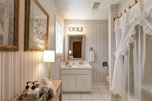 2071 County Road 63, Tuskegee, AL 36083 - full bathroom featuring wallpapered walls, toilet, a textured ceiling, tile patterned floors, and vanity
