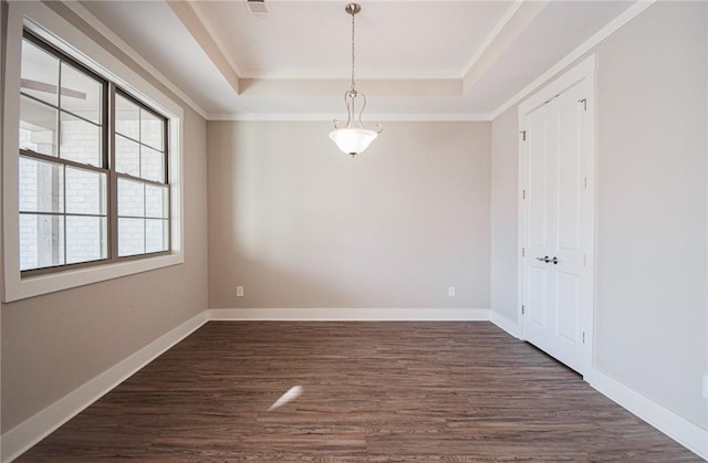 empty room featuring crown molding, a tray ceiling, and dark hardwood / wood-style floors