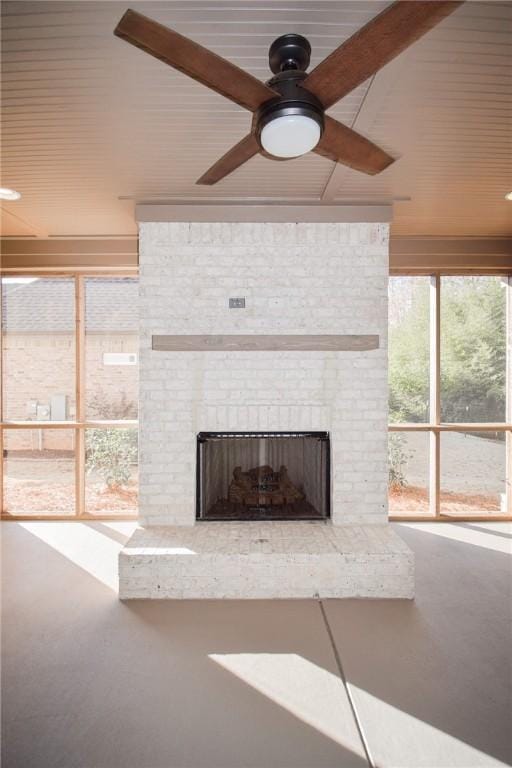 unfurnished living room featuring a brick fireplace and ceiling fan