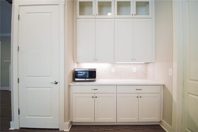 kitchen with white cabinetry, dark wood-type flooring, and decorative backsplash