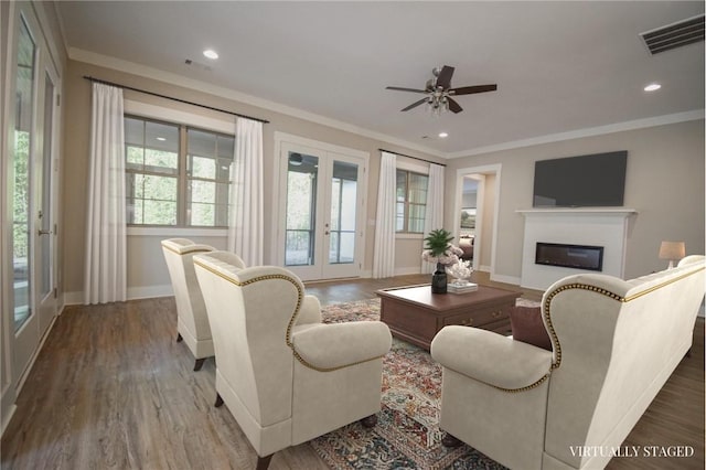 living room featuring wood-type flooring, ceiling fan, crown molding, and french doors