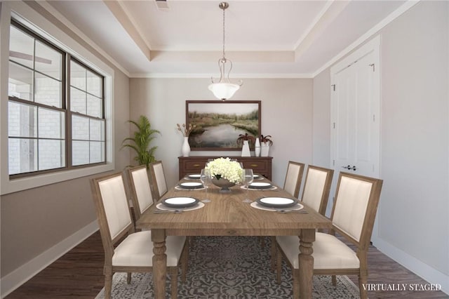 dining area with ornamental molding, dark hardwood / wood-style floors, and a tray ceiling