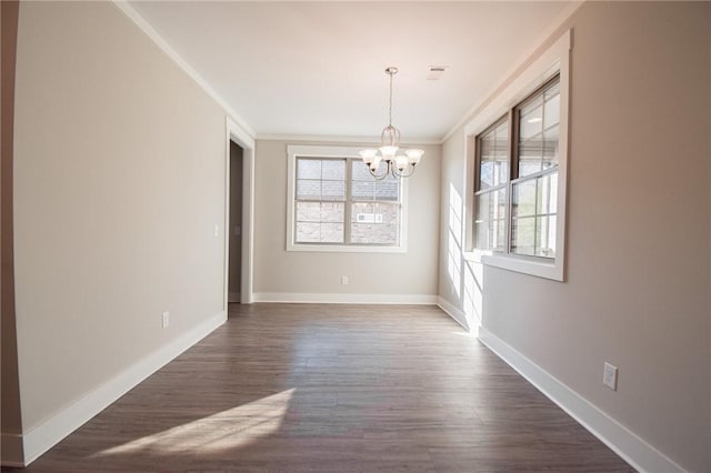 unfurnished dining area with crown molding, dark wood-type flooring, and a notable chandelier