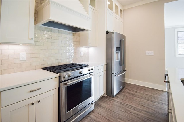 kitchen featuring stainless steel appliances, premium range hood, tasteful backsplash, and white cabinets
