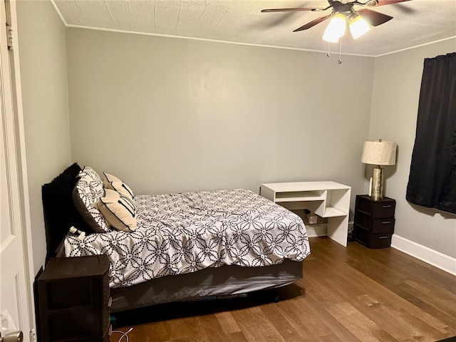 bedroom with ceiling fan, dark wood-type flooring, and a textured ceiling