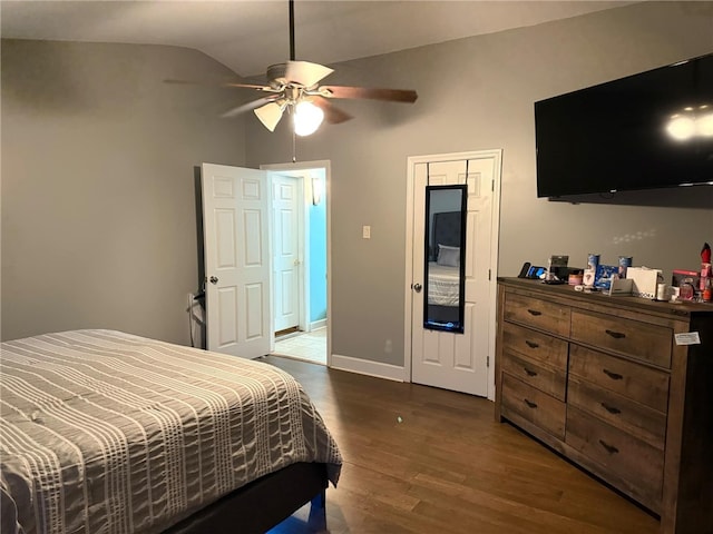 bedroom with ceiling fan, dark hardwood / wood-style floors, and lofted ceiling