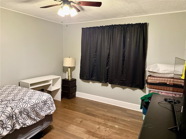 bedroom featuring ceiling fan, wood-type flooring, and a textured ceiling