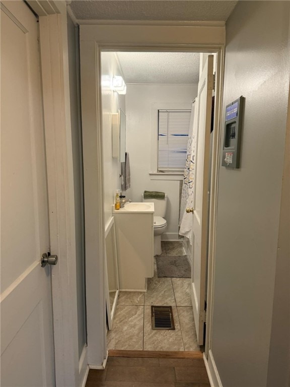 bathroom featuring sink, toilet, and a textured ceiling