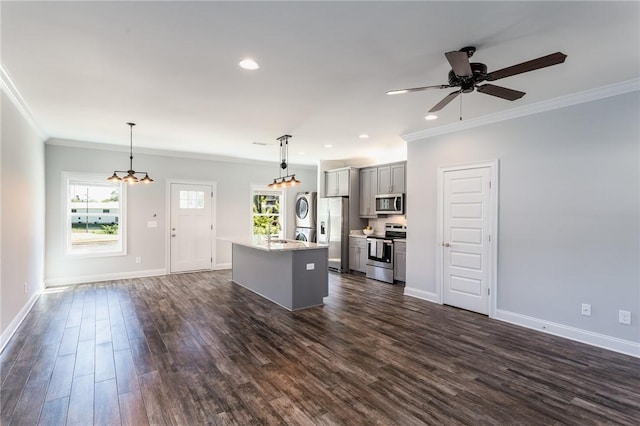 kitchen with appliances with stainless steel finishes, dark hardwood / wood-style floors, gray cabinetry, hanging light fixtures, and a center island