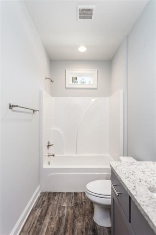 full bathroom with shower / tub combination, vanity, hardwood / wood-style floors, and toilet