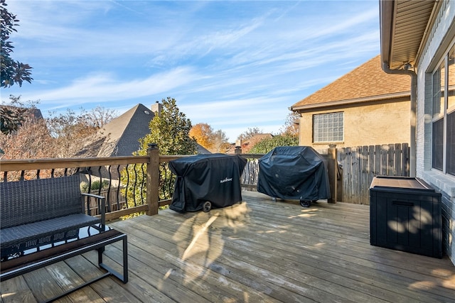 wooden terrace with an outdoor living space and grilling area