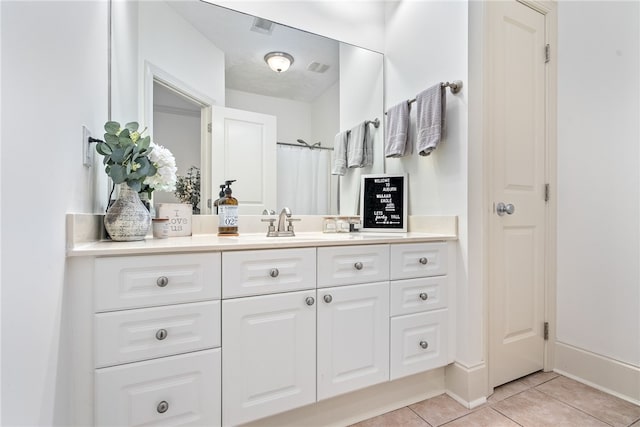 bathroom with tile patterned flooring, a shower with curtain, and vanity