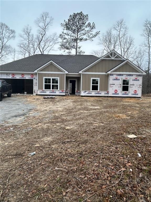 property under construction with an attached garage, driveway, and roof with shingles